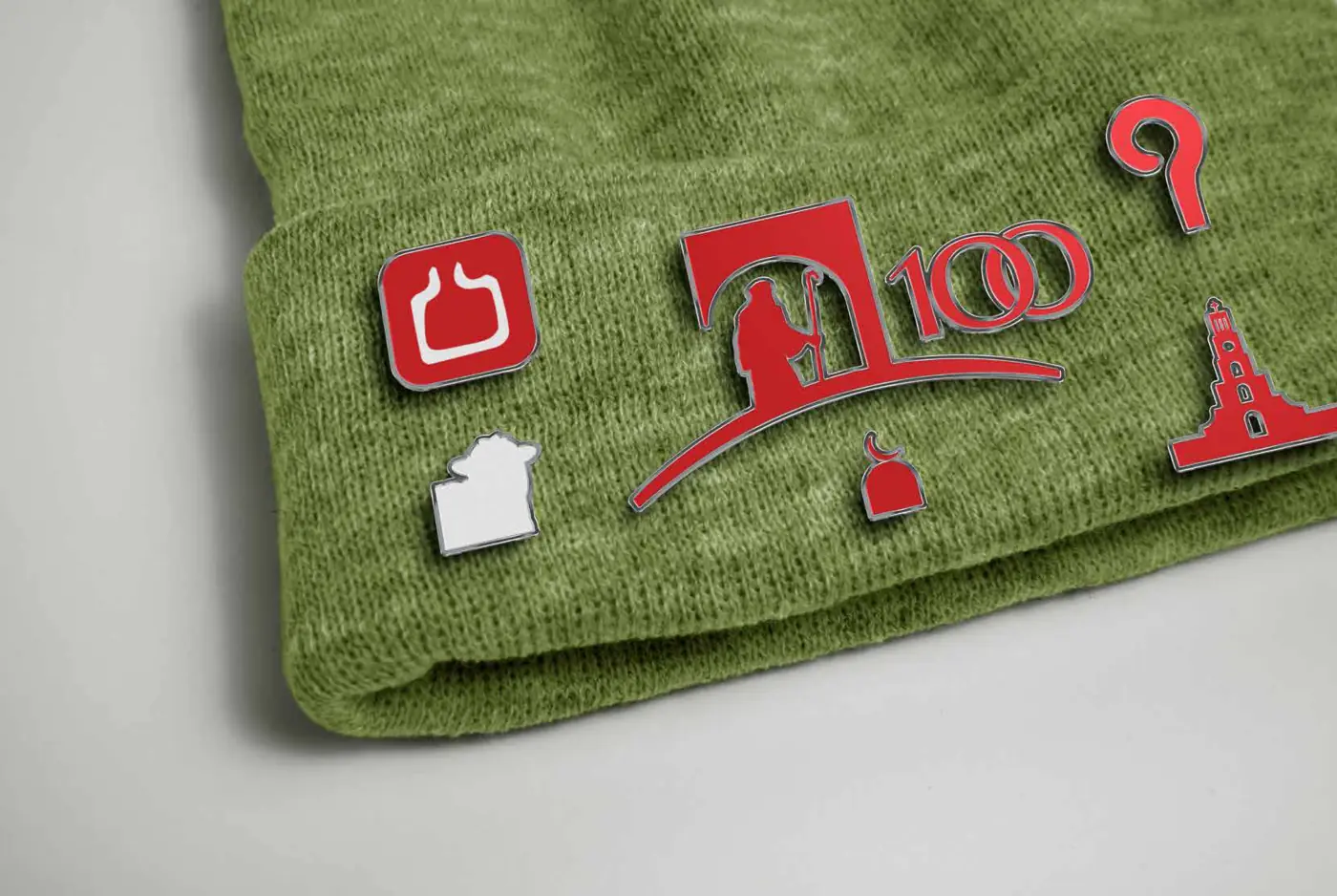 Enamel pins of the centennial icons on a beanie
